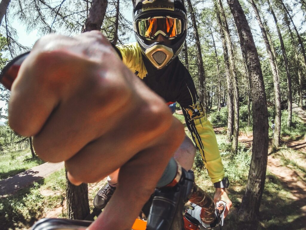 man biking surrounded with tall and green trees